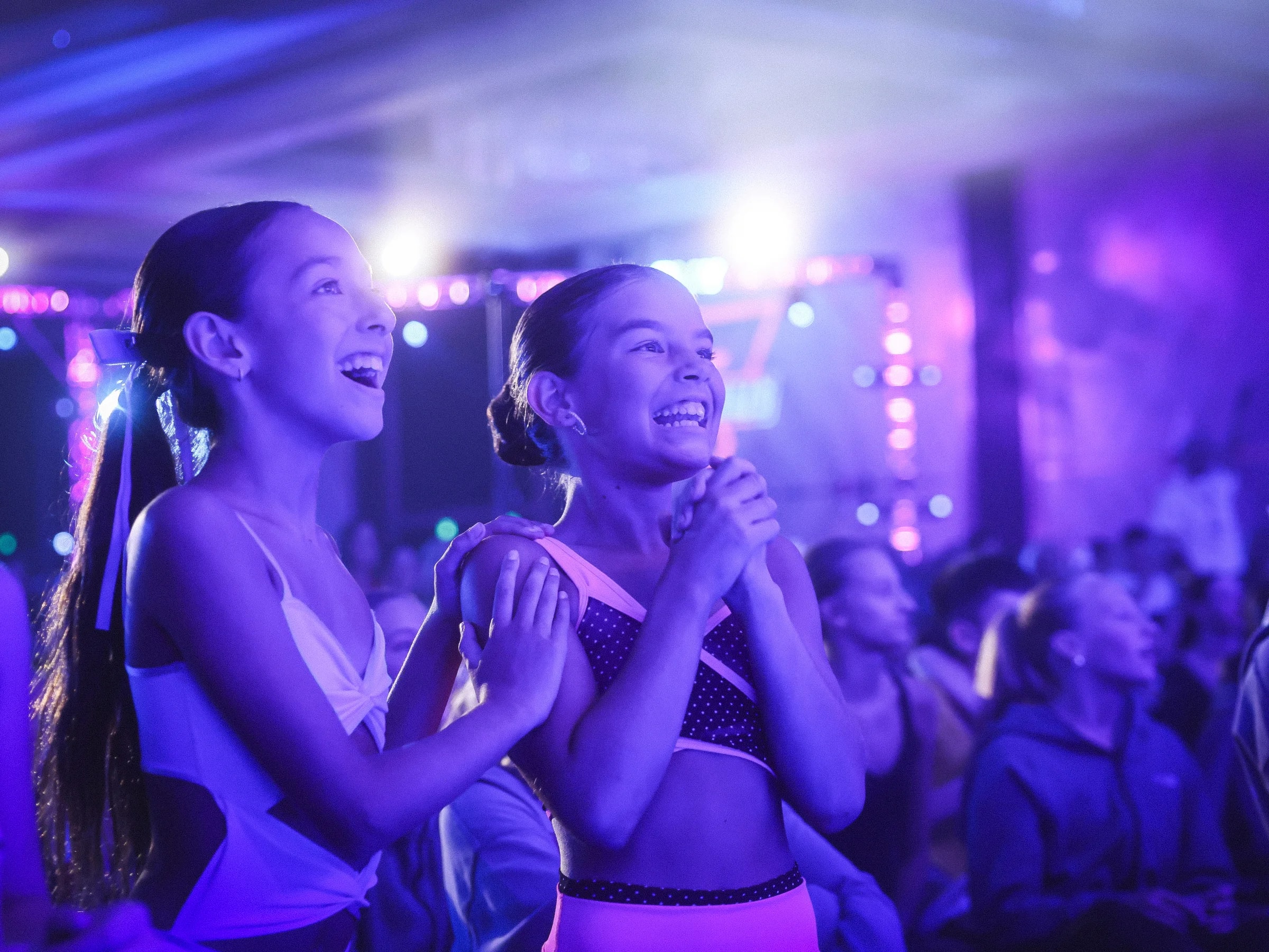 Young dancers smiling and watching a performance